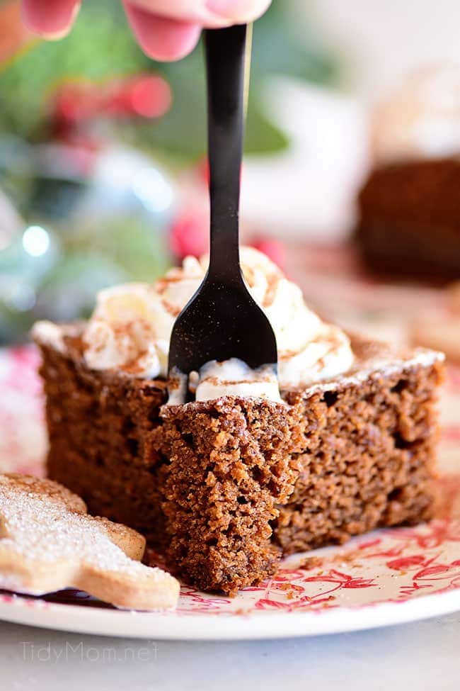 a black forking going into a serving of gingerbread cake on a red 