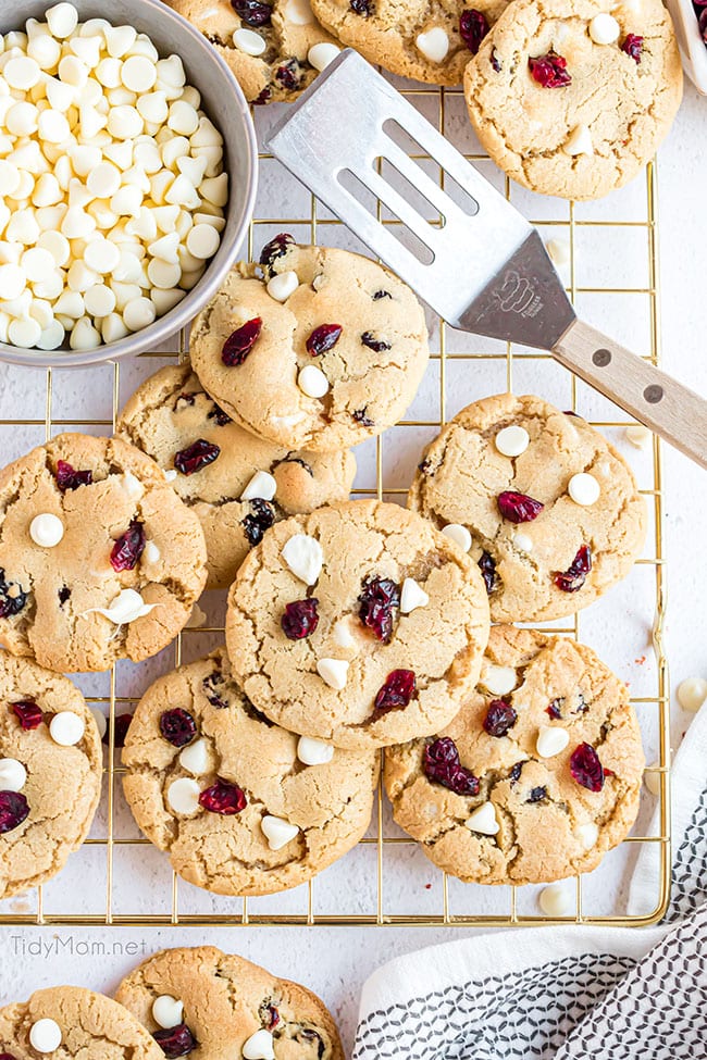 cranberry cookies on a gold cooling rack with spatula