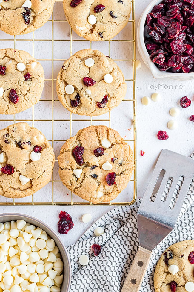 white chocolate cranberry cookies on a gold cooling rack with spatula