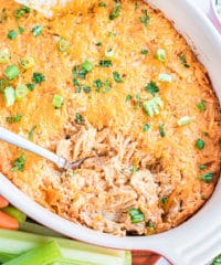 baked buffalo chicken dip in a white dish with a spoon