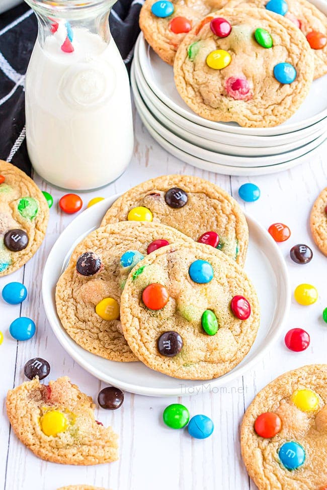 3 m&m cookies on a plate with candies on the counter