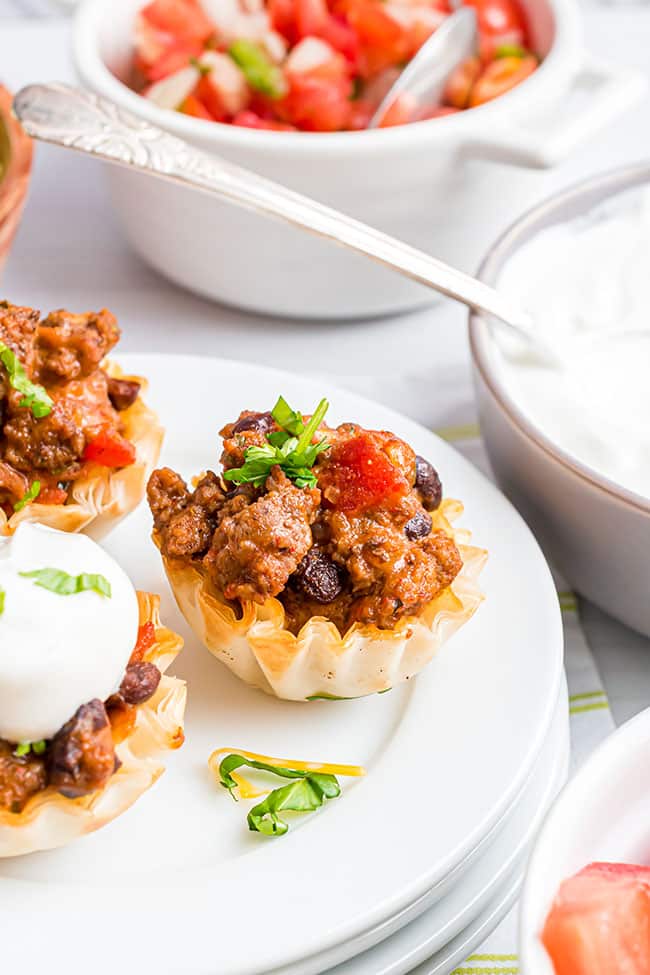 taco bite appetizers in phyllo cups on a plate served with sour cream