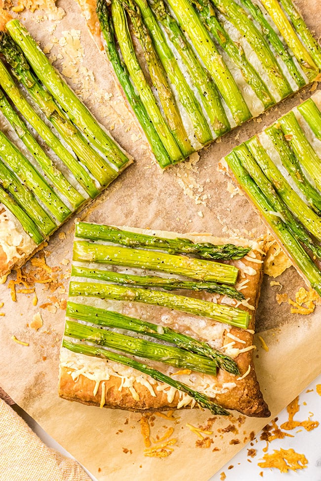 Asparagus gruyere tart cut into servings on a baking sheet