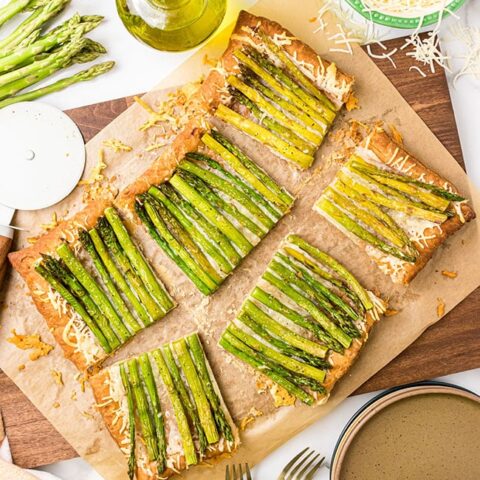 Asparagus gruyere tart cut into servings on a cutting board