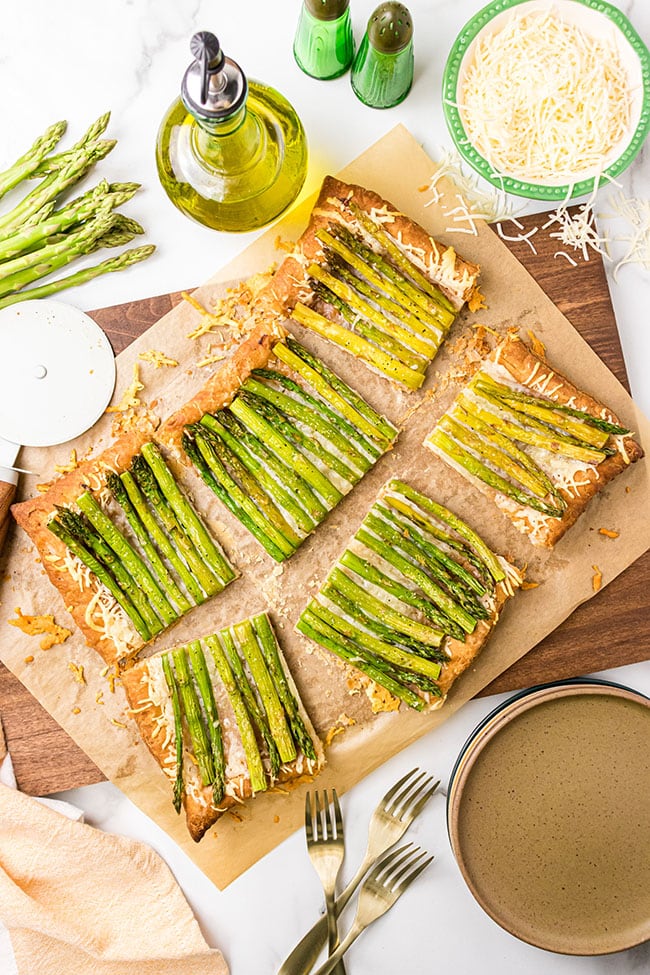 Asparagus gruyere tart cut into servings on a cutting board