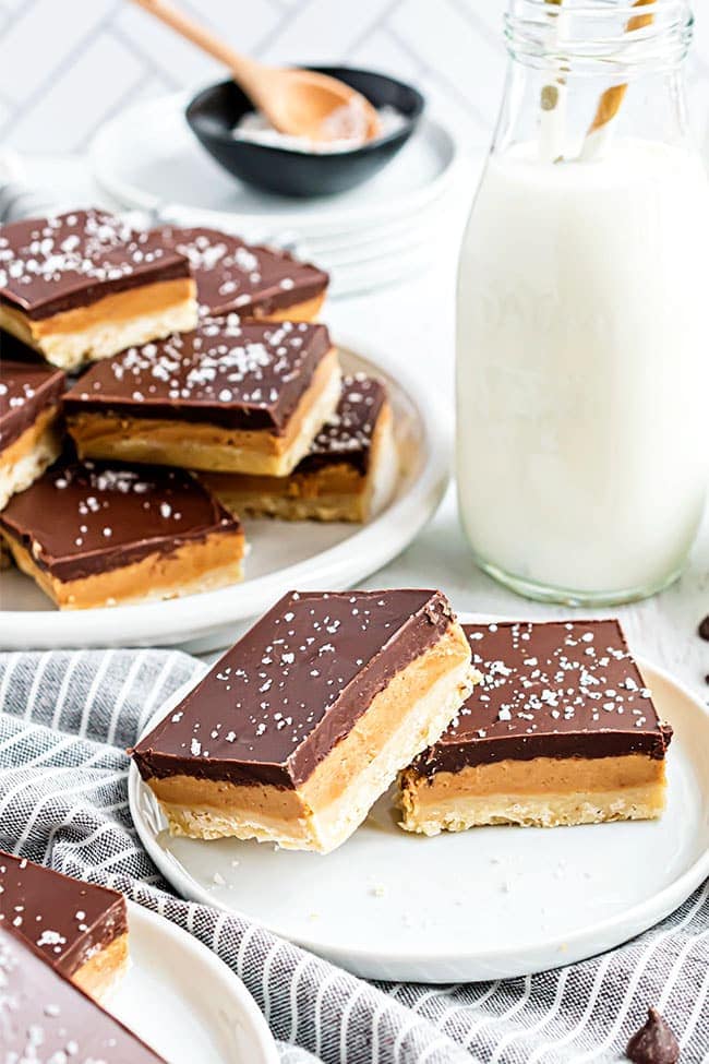 Homemade Tagalong cookie bars on a plate with a blue stripe napkin