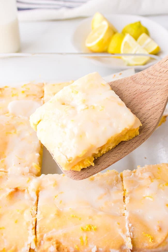 a pan of lemon brownies with one serving on a spatula