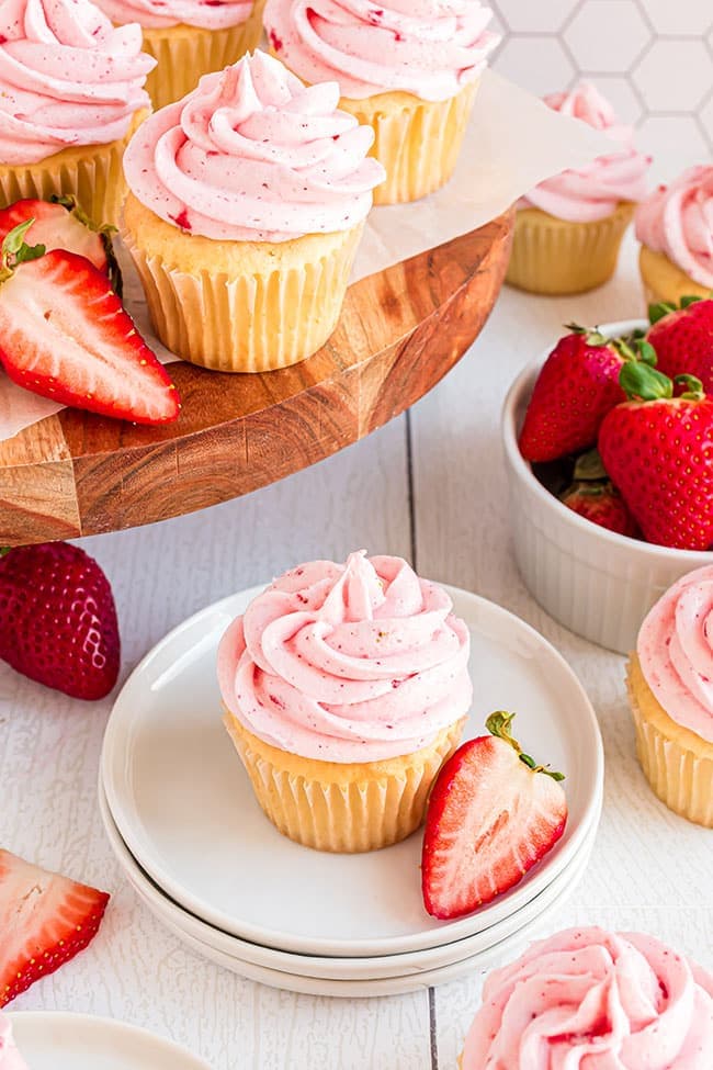 vanilla cupcakes with pink frosting on a white plate