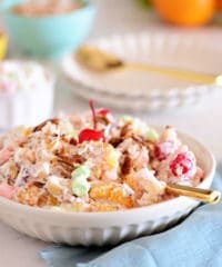 Easy Ambrosia Salad in a white bowl with a gold spoon