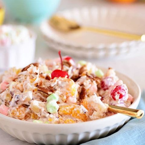 Easy Ambrosia Salad in a white bowl with a gold spoon