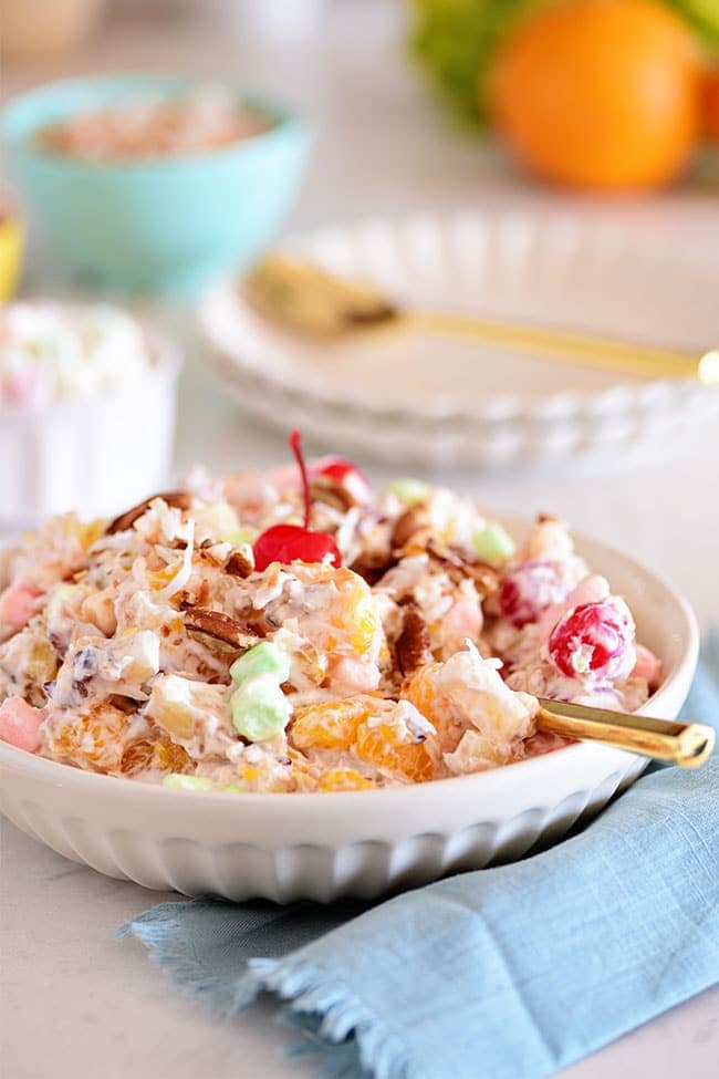 Easy Ambrosia Salad in a white bowl with a gold spoon