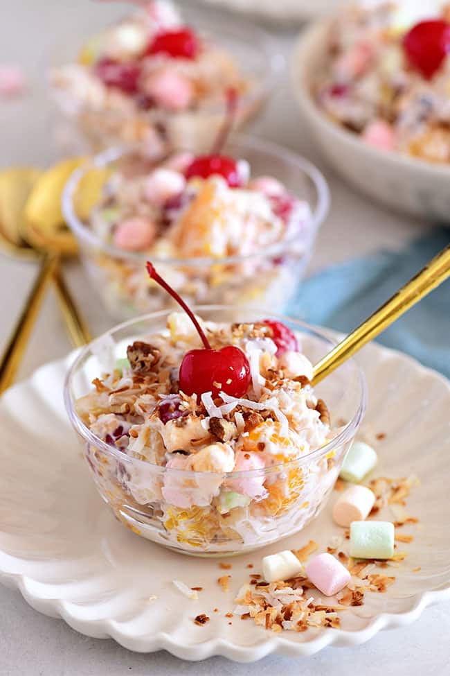 servings of ambrosia salad in dessert cups with a gold spoon