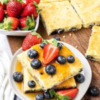 Blueberry Sheet Pan Pancakes on a white plate with fresh berries