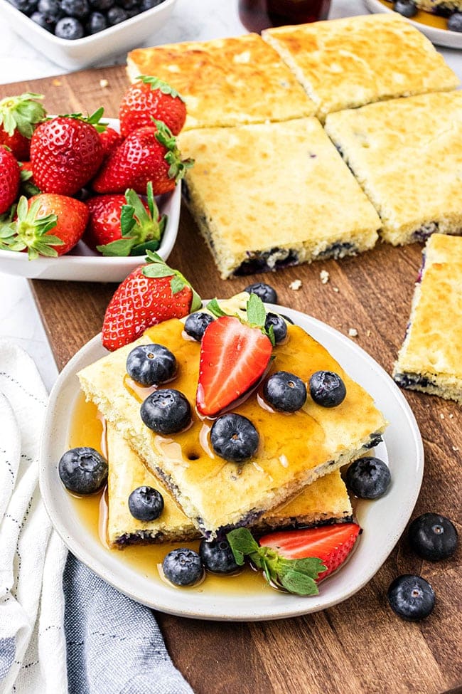 Blueberry Sheet Pan Pancakes on a white plate with fresh berries