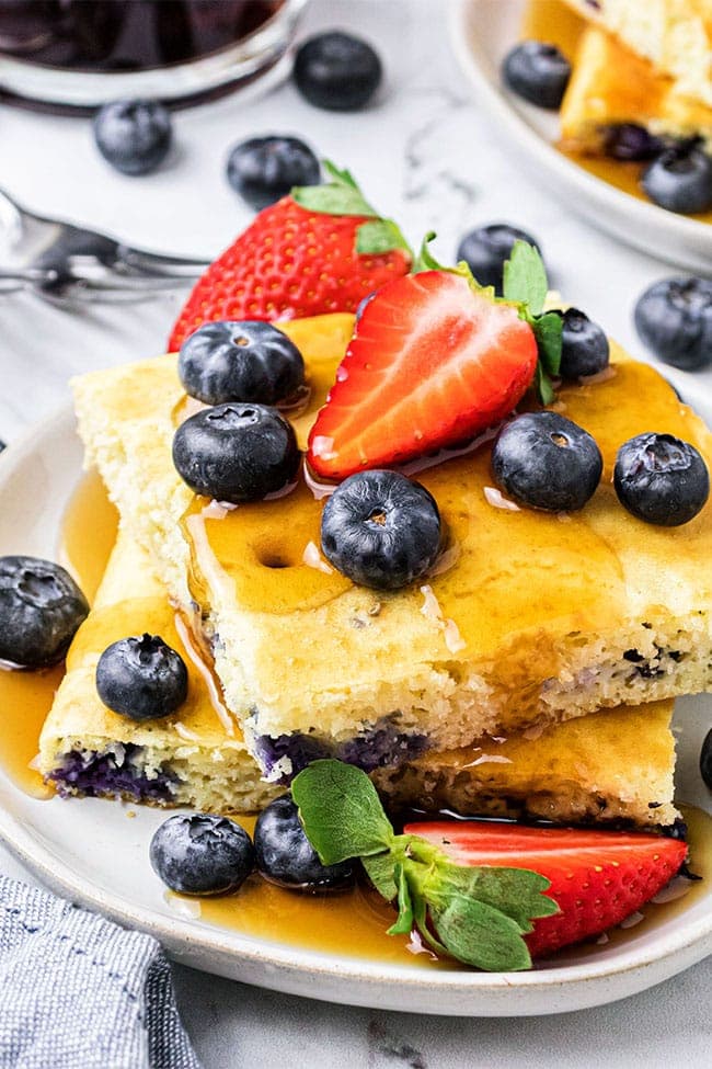 a stack of oven baked pan sheet pancakes on a plate with fresh berries