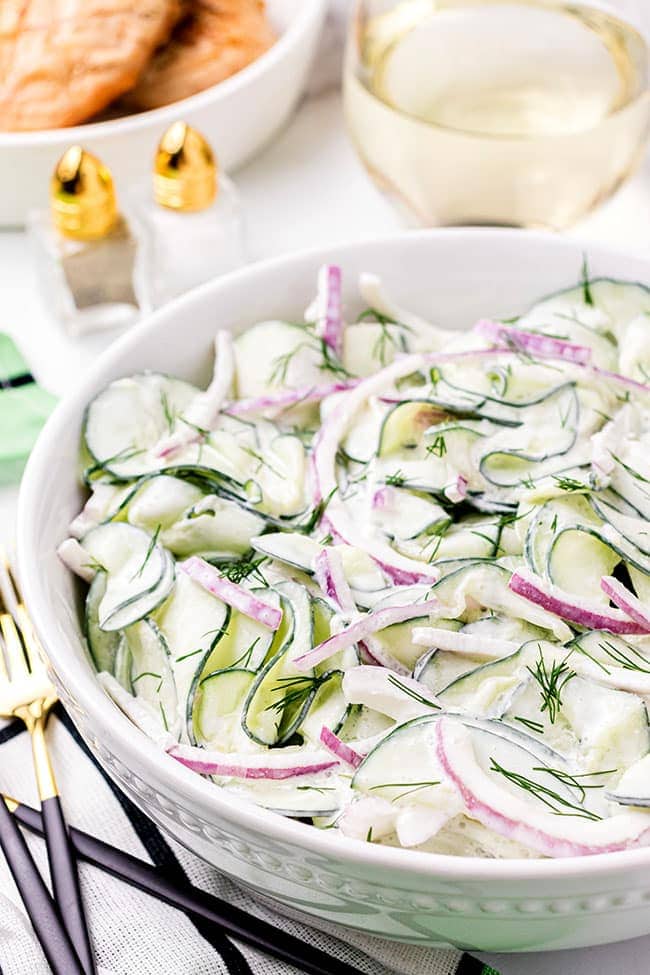 creamy cucumber salad with sour cream in a white bowl