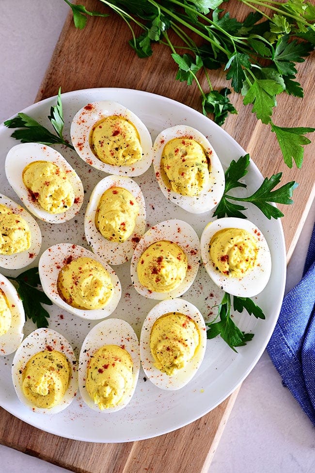 overhead look classic deviled eggs on a white plate with parsley