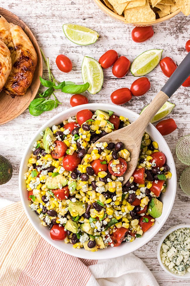 fire roasted corn and black bean salad in a bowl with serving spoon