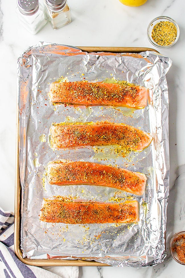 chili salmon with zesty lemon seasoning on a foil lined pan.