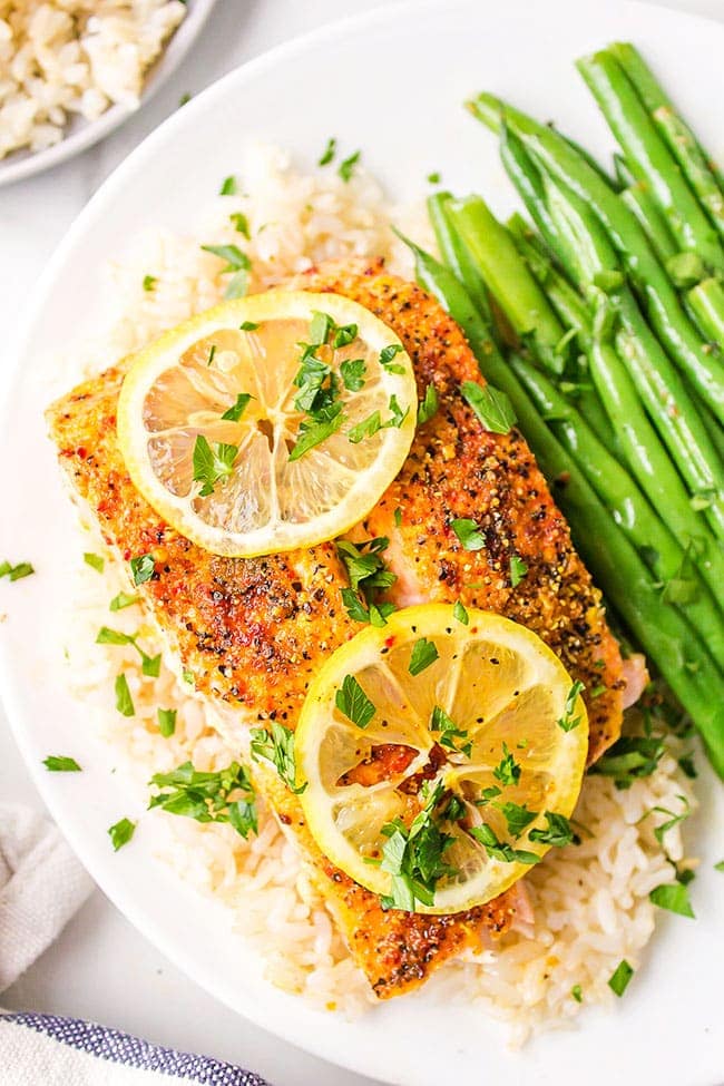 chili lime salmon on a plate with fresh lemon slices and steamed green beans
