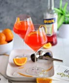 Italian Aperol cocktail in wine glasses with fresh oranges