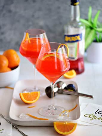 Italian Aperol cocktail in wine glasses with fresh oranges