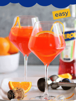 Aperol Spritz cocktail in wine glasses with fresh oranges
