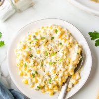 Easy Cream Cheese Corn on a plate and by a slow cooker