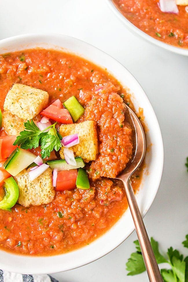 gazpacho in a white bowl with a spoon