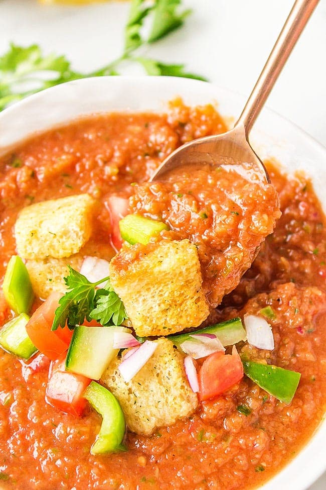 spoonful of summer gazpacho in a white bowl