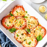 baked tomatoes with cheese in a white baking dish