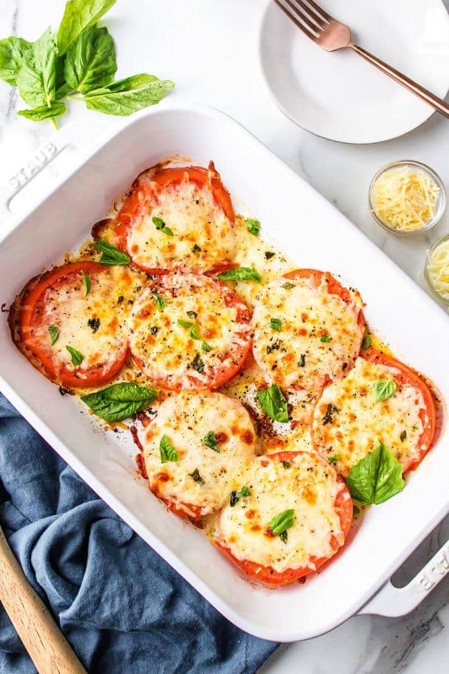 baked tomatoes with cheese in a white baking dish