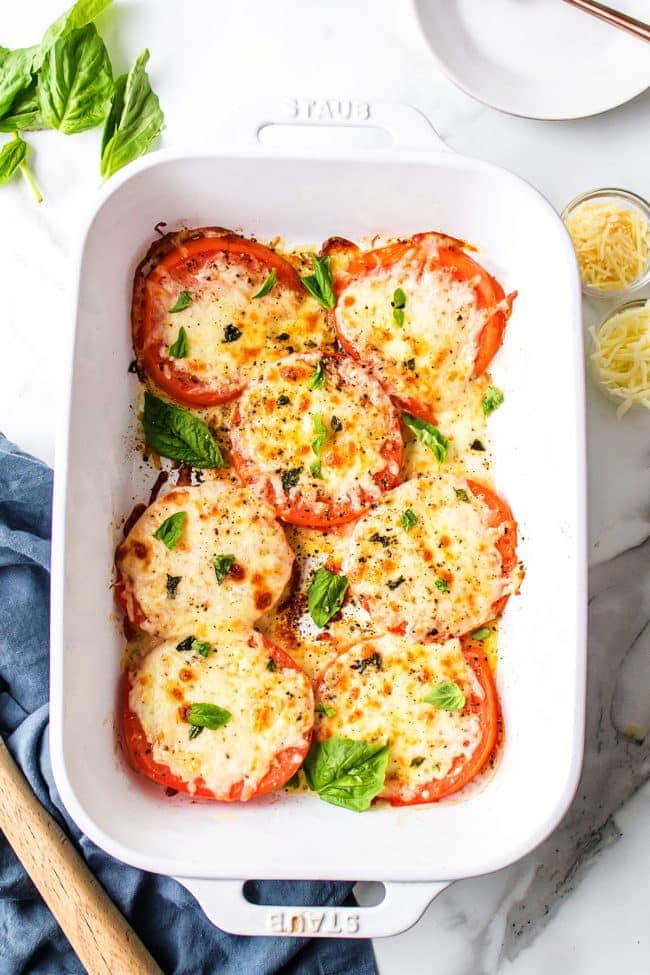 Oven baked tomatoes with mozzarella in a white dish