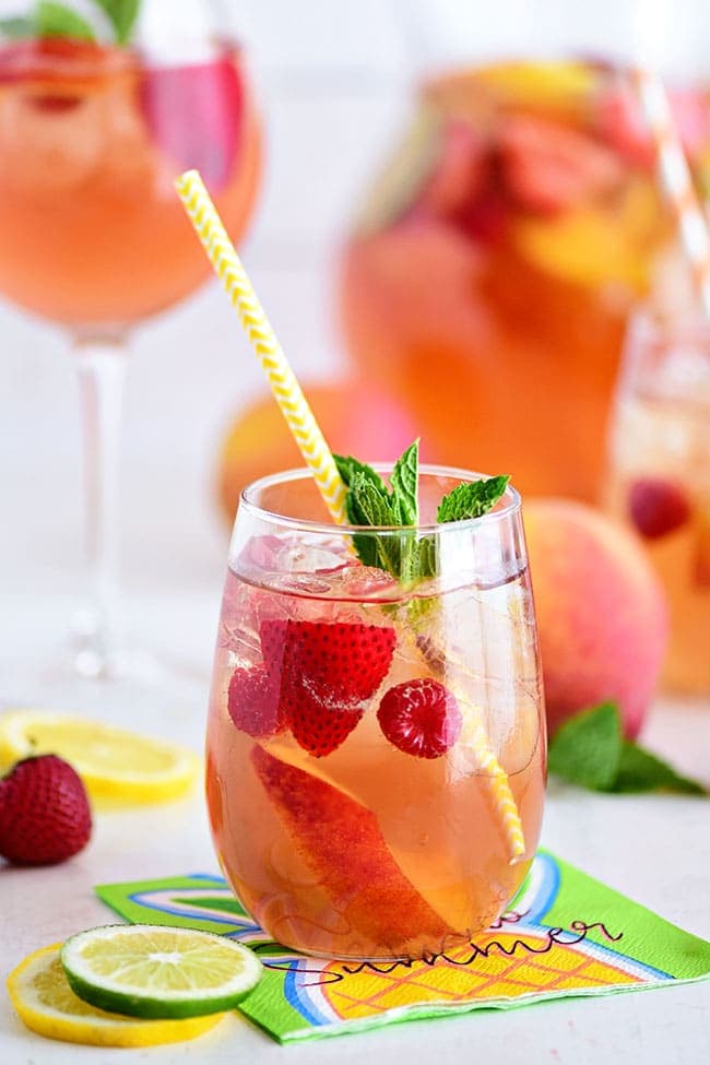 White sangria with peaches and Rosé wine in a glass with fruit