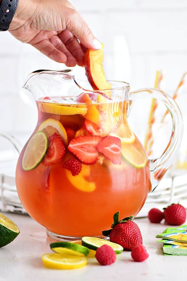 A pitcher of White sangria with peaches and Rosé with fruit