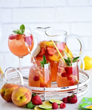 PEACH SANGRIA in a pitcher and wine glasses