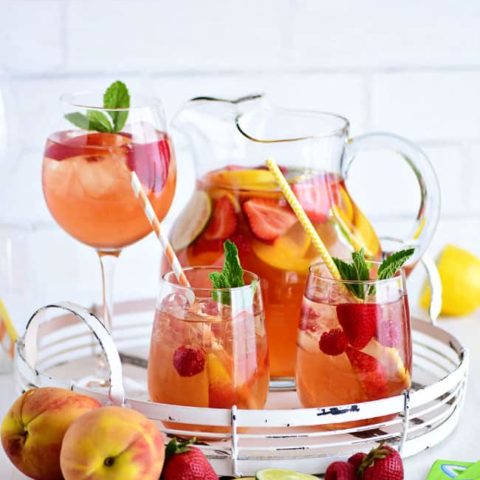 PEACH SANGRIA in a pitcher and wine glasses