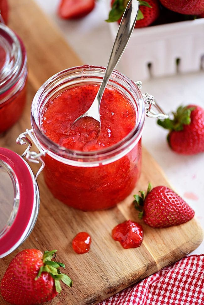 an open jar of no-cook strawberry jam with a spoon