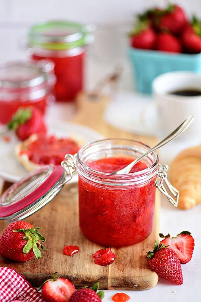 an open jar of Strawberry Freezer Jam with fresh berries