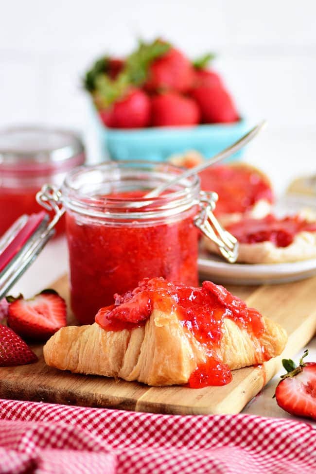 No-cook Strawberry Freezer Jam spread on a buttery croissant