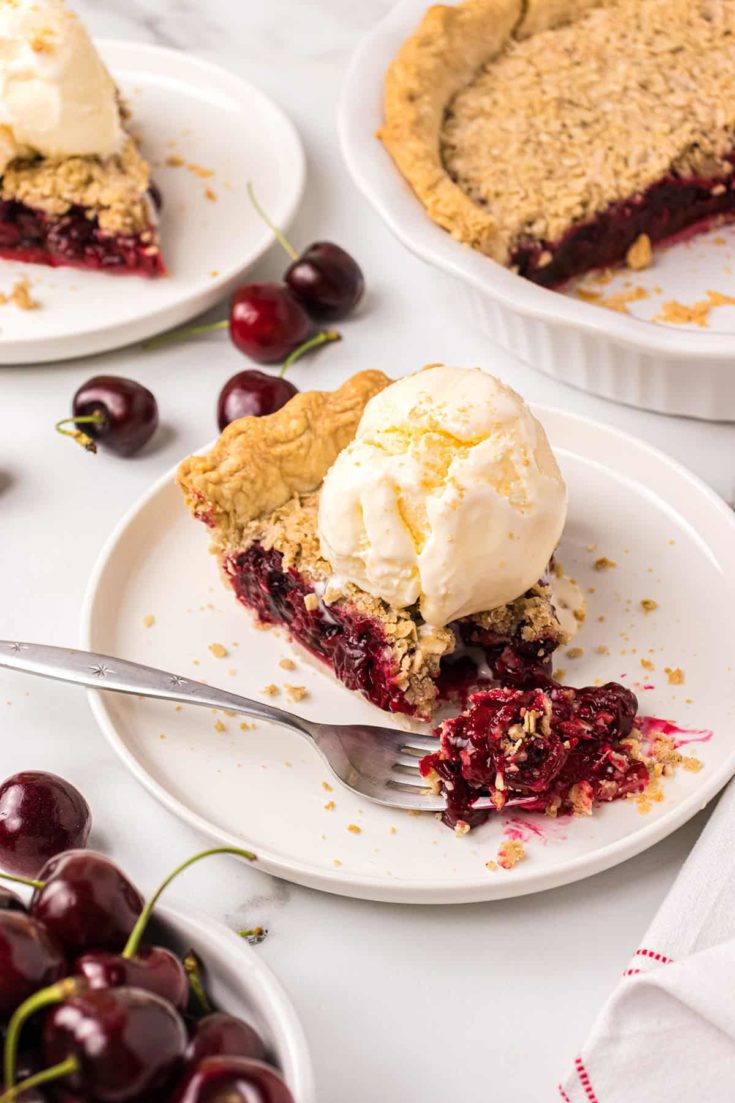 A bite of cherry pie on a fork