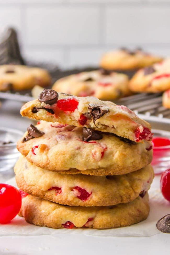 a stack of four chocolate chip cookies with maraschino cherries