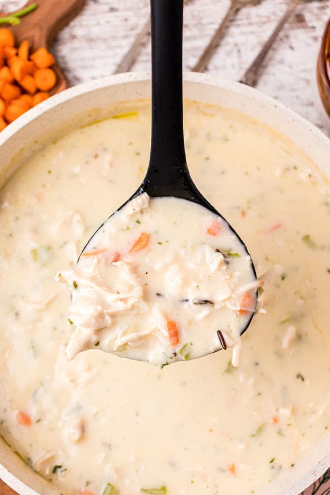 a ladle full of Creamy Chicken And Wild Rice Soup