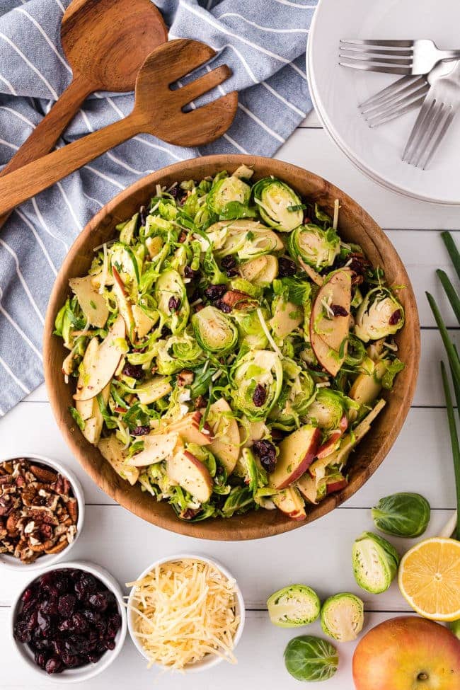 Wood bowl with shredded Brussels Sprouts Salad with apples, pecans and cranberries