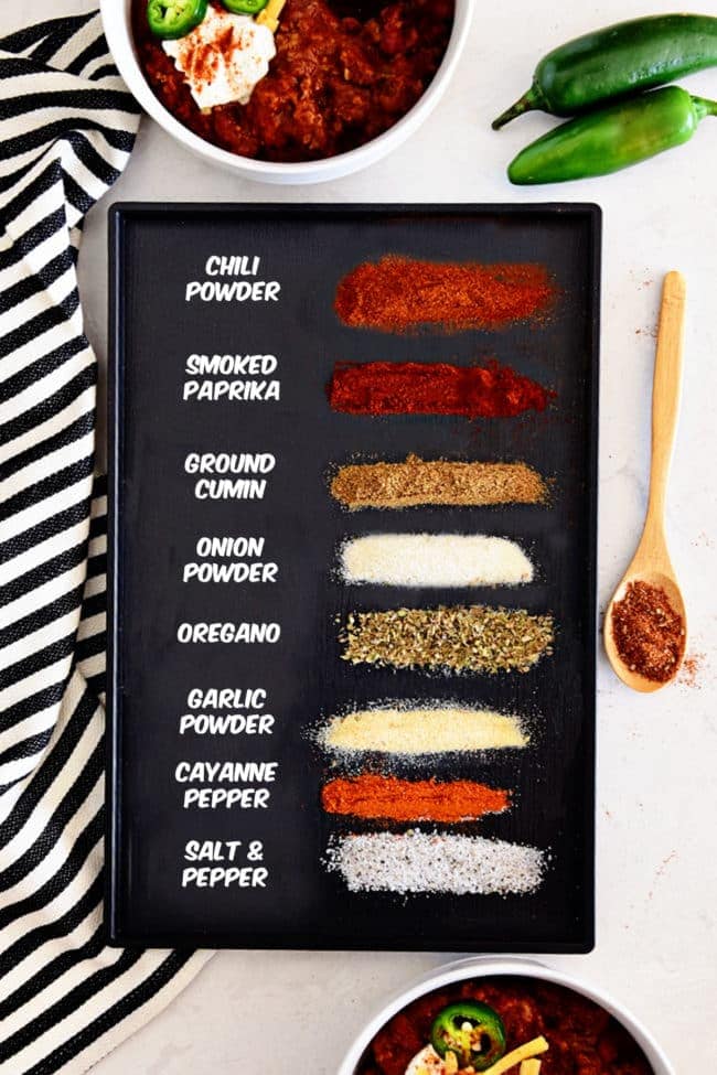 spices needed to make homemade chili seasoning on a black tray