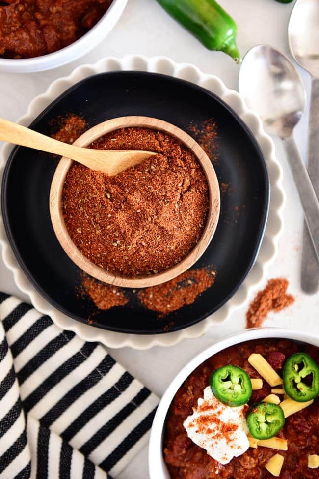 bowl of homemade chili seasoning mix with a bowl of chili