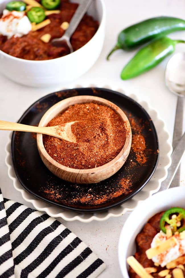 bowls of chili along side homemade chili mix in a wood bowl