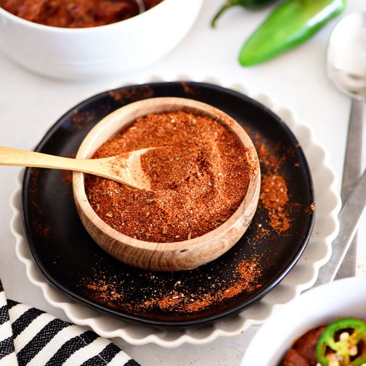 bowls of chili along side homemade chili mix in a wood bowl