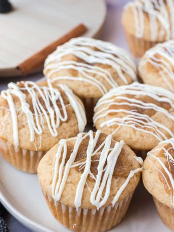 cinnamon roll muffins with white chocolate icing on a plate
