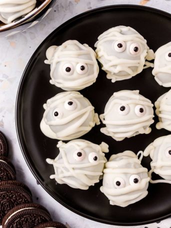 Easy Mummy Oreo Truffles on a black plate for halloween